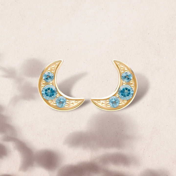 135E1819019 Night Sky London Blue Topaz Moon Stud Earrings in 9ct Yellow Gold On Model